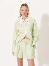 Short amarillo de tiro alto con pinzas delanteras y cierre invisible lateral.