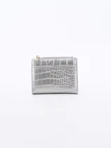 Billetera pequeña plateada con textura tipo piel de cocodrilo y cierre dorado.