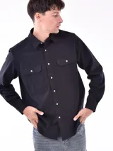 Camisa negra de manga larga con dos bolsillos frontales con botón.