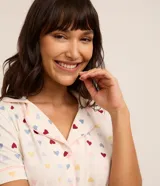 Pijama americano corto de viscosa con estampa de corazones, compuesto por una camisa de manga corta con cuello inglés y cierre de botones, y un short con cintura elástica.