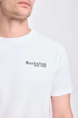 Remera blanca de manga corta con estampa en la espalda de la ciudad de Manhattan y texto en color dorado.
