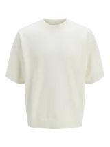 Remera color crema de tejido plano con fit relajado y hombros caídos, cuello redondo y mangas cortas.