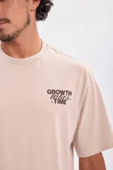 Remera color beige de corte oversize con estampa en la espalda con la frase "Trust the process".