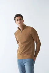 Buzo negro de algodón con cuello alto y medio cierre. Tiene logo bordado en el pecho y puños en las mangas.