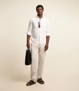 Camisa celeste de lino con cuello camisero, abotonadura frontal y mangas largas.