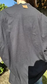 Remera negra de algodón, corte amplio, cuello redondo y mangas cortas.