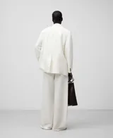 Pantalón de vestir de lino y viscosa color blanco, corte palazzo, con trabillas, pinzas delanteras, bolsillos laterales y bolsillos de vivo en la espalda.