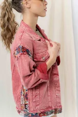 Campera de jean oversize, color rojo desgastado, con aplicaciones de tapicería multicolor de estilo étnico en hombros y ruedo, y terminaciones desflecadas.