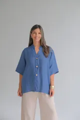 Camisa azul jean de lino, con cuello mao, manga corta y cierre frontal con botones.
