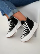 Championes negros de corte alto, con suela blanca y cordones.