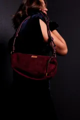 Cartera tipo sobre color bordó, confeccionada en PU tipo gamuza, con correa regulable de nudos chunky y cierre superior.