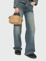 Bolso tipo crossbody color beige con estampado del logo de la marca en el frente.
