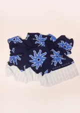 Pareo rectangular de viscosa con estampado de flores rojas sobre fondo borgoña y borde inferior con rayas verticales rojas, amarillas y blancas.