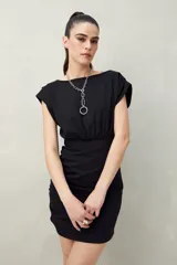 Vestido corto color marrón, con escote redondo, mangas cortas con hombreras y frunces laterales.