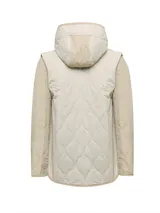 Campera beige acolchada con diseño de rombos, cierre con botones a presión, capucha y bolsillos delanteros. Las mangas son desmontables, transformándose en chaleco, y es reversible.