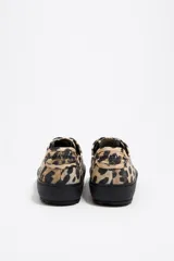 Zapatillas deportivas bajas con estampado animal print, puntera y suela de goma negra y cordones negros.