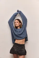 Sweater de punto color borgoña con cuello redondo y diseño de trenzas verticales.