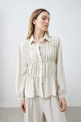 Camisa beige melange con frunces en el frente, de manga larga y cuello camisero.