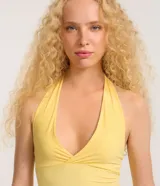 Top corto frente única color amarillo, confeccionado en microfibra sin estampa, con breteles anchos y escote V cruzado.