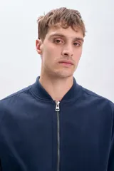 Campera bomber azul marino con cierre frontal, cuello, puños y ruedo acanalados.