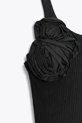 Top blanco de morley con escote redondo y tirantes. Detalle de flor en relieve combinada al tono.