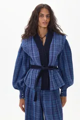 Chaleco azul con estampado a cuadros, con cuello en V y cinturón de terciopelo negro.