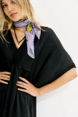 Vestido midi negro de calce amplio y mangas al codo. Tiene apliques de gasa en escote y mangas, y recortes con frunce en la cintura.