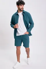 Bermuda casual de hombre color verde azulado, con cintura ajustable mediante cordón y bolsillos laterales.