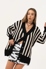Saco oversize tejido a rayas verticales en blanco y negro, con escote en V y botones.
