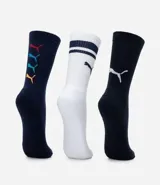 Kit de tres pares de medias deportivas Puma de caña larga. Un par color beige con dos rayas marrones horizontales en la parte superior y logo marrón en el tobillo. Un par color crema liso con logo blanco en el tobillo. Un par color marrón con una raya blanca horizontal en la parte superior y logo blanco en el tobillo.