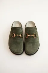 Mocasines tipo sueco de cuero gris con detalle de hebilla dorada.