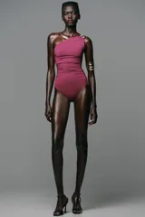 Body fucsia de poliamida con escote asimétrico, un solo tirante con pieza metálica dorada y frunces laterales.
