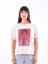 Remera color crudo con estampado de retrato de mujer afroamericana con aros dorados y chaqueta con estampado animal print en tonos rosados y celestes.