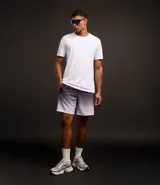 Bermuda deportiva masculina con cintura elástica, cordón interno de ajuste y forro de malla. Diseño con cuadros difuminados en degrade de gris oscuro a blanco.