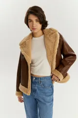 Campera de estilo aviador en color marrón, confeccionada en cuero sintético con interior y detalles de corderito en color beige en cuello, puños y ruedo.