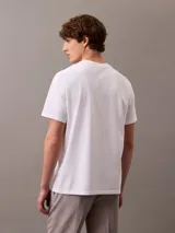 Remera blanca de algodón con cuello redondo y manga corta. Presenta un logo bordado de CK Shield en el pecho.