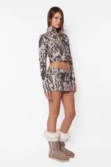 Minifalda de sarga gamuzada con estampado animal print, cierre frontal metálico y recortes horizontales con cierres laterales.