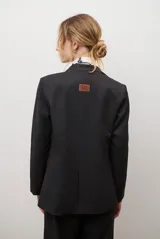 Blazer azul de jean textil, con solapa clásica, un botón frontal y bolsillos laterales.