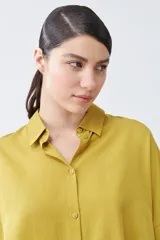 Camisa color pistacho de lyocell con cuello clásico, cierre frontal con botones y mangas cortas.