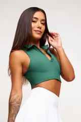 Top deportivo azul marino con cuello polo y cierre parcial con cremallera.