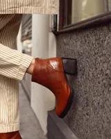 Botines negros de cuero con estampado de cocodrilo, taco cuadrado y cierre lateral con cremallera.