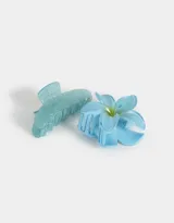 Set de dos broches para el pelo, uno con forma de flor celeste y otro con forma de pinza celeste con glitter.