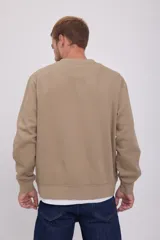 Buzo color arena de manga larga y cuello redondo, con logo "Originals Studio" estampado en el pecho.