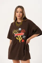 Remerón marrón de algodón con estampado de motivos marinos en colores amarillo, naranja, rojo, azul y blanco. De calce oversize y largo extendido.