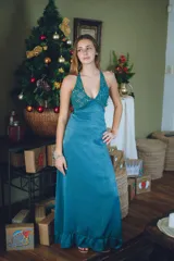 Vestido largo color marrón cobrizo con escote en V, cut outs laterales bajo el busto y breteles finos que se cruzan y atan en la espalda. Presenta un top con estampado abstracto en tonos marrones y dorados.