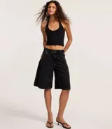 Blusa blanca de punto roma, con diseño de cuello halter que deja la espalda descubierta.