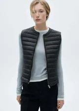 Chaleco negro acolchado con cierre frontal y cuello redondo.