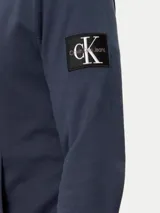 Buzo con capucha Calvin Klein color azul petróleo, con bolsillo tipo canguro, cordones ajustables y logo de la marca en la manga. Confeccionado en felpa de algodón.
