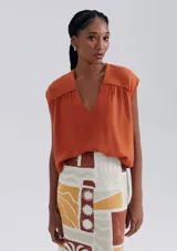 Blusa sin mangas de corte holgado, con escote en V y color naranja.