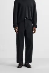 Pantalón de jean color crudo, corte amplio y tiro alto, con cinco bolsillos y cierre frontal con botones.